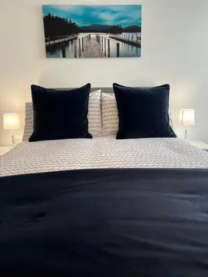 a bed with two pillows and a painting on the wall at Blackpool Abode - Silver Sands in Blackpool