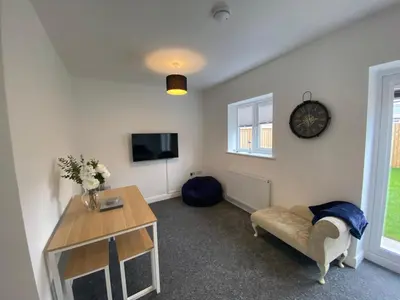 a living room with a couch and a table and a tv at Blackpool Abode - Silver Sands in Blackpool