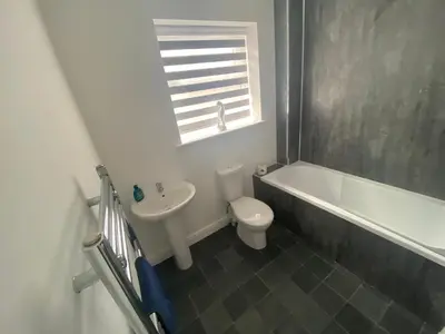 a bathroom with a toilet and a tub and a sink at Blackpool Abode - Silver Sands in Blackpool