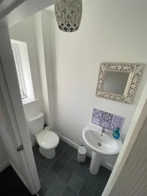 a white bathroom with a toilet and a sink at Blackpool Abode - Silver Sands in Blackpool