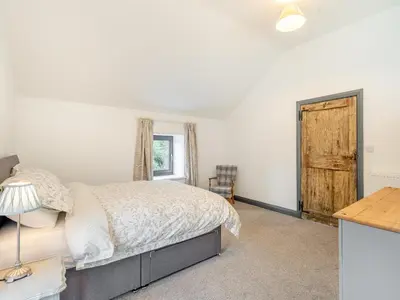 a bedroom with a bed and a desk and a window at The Granary in Inglewhite