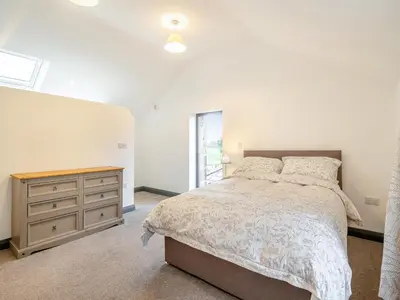 a bedroom with a bed and a dresser and a window at The Granary in Inglewhite