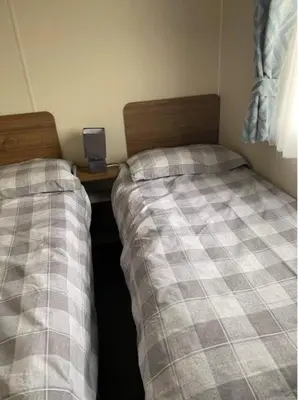 two beds sitting next to each other in a room at Adams Caravan Holidays in Morecambe