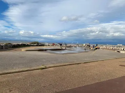 a road with a body of water next to a beach at Adams Caravan Holidays in Morecambe