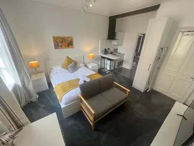 a bedroom with a bed and a couch and a chair at Sun Street Aparthotel in Lancaster