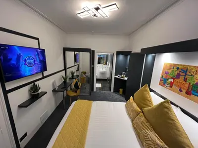 a bedroom with a bed and a tv on a wall at Sun Street Aparthotel in Lancaster