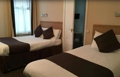 a hotel room with two beds and a window at Lord Nelson Hotel-Lime Street Station Liverpool by Compass Hospitality in Liverpool