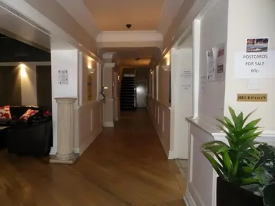 a hallway in a building with white walls and wood floors at Lord Nelson Hotel-Lime Street Station Liverpool by Compass Hospitality in Liverpool