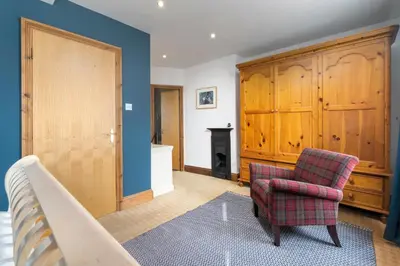 a living room with a chair and a fireplace at Clare's Cottage Near Cartmel - Dog Friendly, Homely, Aga, Log Burners, Disney Plus & Netflix in Holker