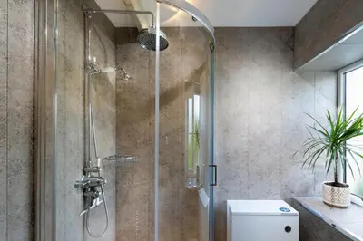 a shower with a glass door in a bathroom at Clare's Cottage Near Cartmel - Dog Friendly, Homely, Aga, Log Burners, Disney Plus & Netflix in Holker