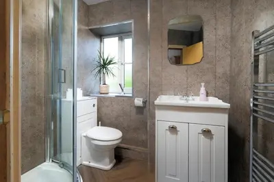 a bathroom with a toilet and a sink and a shower at Clare's Cottage Near Cartmel - Dog Friendly, Homely, Aga, Log Burners, Disney Plus & Netflix in Holker