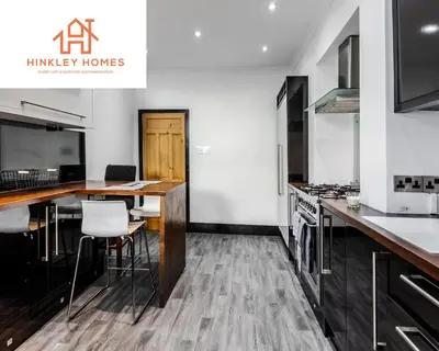 a kitchen with a table and a counter top at Supersized 5bed - Free parking - 8 beds - Anfield - By Hinkley Homes Short Lets & Serviced Accommodation in Liverpool