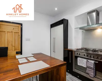 a kitchen with a wooden counter top and a stove at Supersized 5bed - Free parking - 8 beds - Anfield - By Hinkley Homes Short Lets & Serviced Accommodation in Liverpool