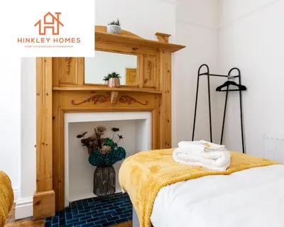 a bedroom with a fireplace with towels on a bed at Supersized 5bed - Free parking - 8 beds - Anfield - By Hinkley Homes Short Lets & Serviced Accommodation in Liverpool