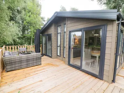 a tiny house with a deck with a table at Coniston View 9 in Carnforth