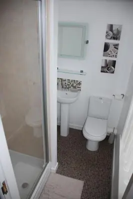 a bathroom with a toilet and a sink and a shower at Wendover Guest House in Bolton
