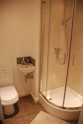a bathroom with a shower and a toilet and a sink at Wendover Guest House in Bolton