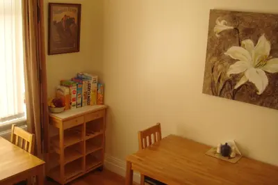 a dining room with a table and a table and chairs at Wendover Guest House in Bolton