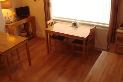 a dining room with a table and chairs and a window at Wendover Guest House in Bolton