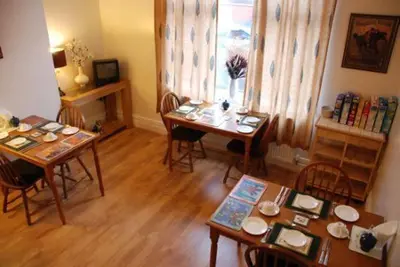 a living room with tables and chairs and a window at Wendover Guest House in Bolton