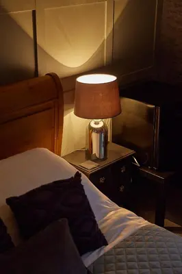a bedroom with a bed and a lamp on a table at The Ribchester Arms in Blackburn