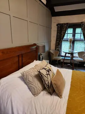 a bedroom with a bed with white sheets and pillows at The Ribchester Arms in Blackburn