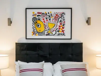 a bed with a black headboard with a picture above it at The Anfield Hotel in Liverpool