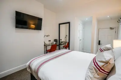 a hotel room with a bed and a desk at The Anfield Hotel in Liverpool