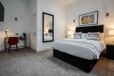 a bedroom with a large bed and a mirror at The Anfield Hotel in Liverpool