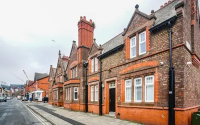 a row of brick buildings on a street at The Anfield Hotel in Liverpool