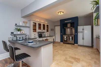 a large kitchen with a large island in the middle at Orchard Lodge in Lytham St Annes