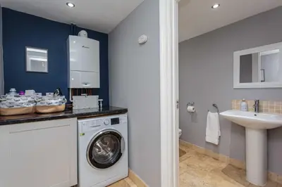 a bathroom with a washing machine and a sink at Orchard Lodge in Lytham St Annes