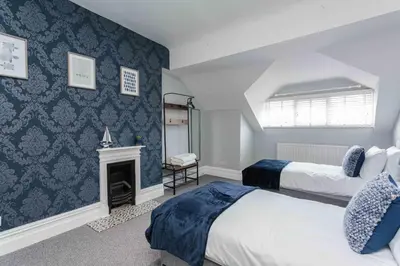 a bedroom with two beds and a fireplace at Orchard Lodge in Lytham St Annes