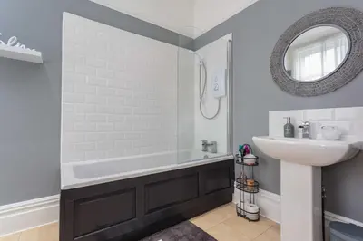 a bathroom with a bath tub and a sink at Orchard Lodge in Lytham St Annes