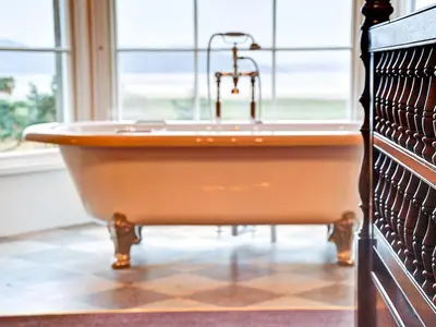 a bath tub with a sink in a room with a window at Bay Villa in Grange Over Sands