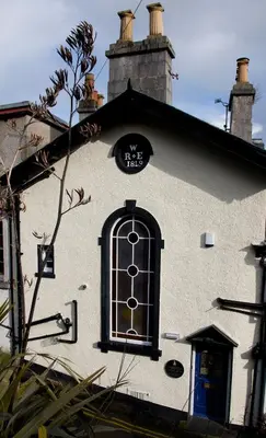 a white building with a window and a clock on it at Bay Villa in Grange Over Sands