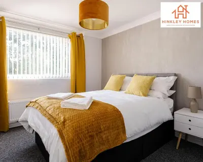 a bedroom with a large bed with yellow curtains at Spacious 3 bedroom house with wifi and car parking By Hinkley Homes Short Lets & Serviced Accommodation in Waterloo