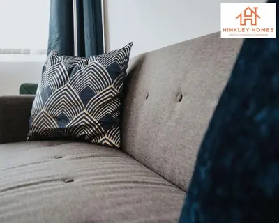a brown couch with a pillow on it at Spacious 3 bedroom house with wifi and car parking By Hinkley Homes Short Lets & Serviced Accommodation in Waterloo
