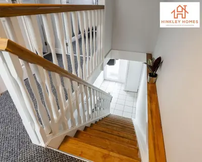 a staircase in a home with white walls and wood floors at Spacious 3 bedroom house with wifi and car parking By Hinkley Homes Short Lets & Serviced Accommodation in Waterloo