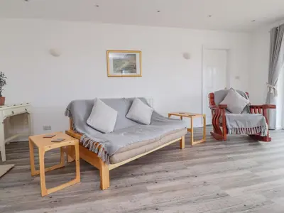 a living room with a couch and a chair at Sea La Vie in Lytham St Annes
