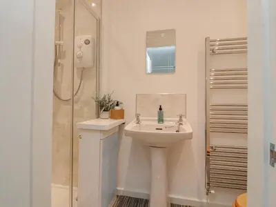 a white bathroom with a sink and a shower at Sea La Vie in Lytham St Annes