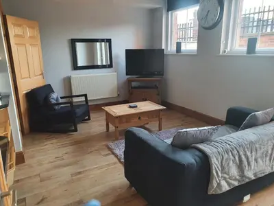 a living room with a couch and a coffee table at Spacious 2 bed appartment next to BAE with spa bath in Barrow in Furness