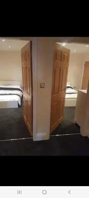 two open doors in a room with two beds at Spacious 2 bed appartment next to BAE with spa bath in Barrow in Furness