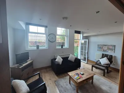 a living room with a couch and a table at Spacious 2 bed appartment next to BAE with spa bath in Barrow in Furness