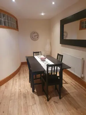 a dining room with a black table and chairs at Spacious 2 bed appartment next to BAE with spa bath in Barrow in Furness