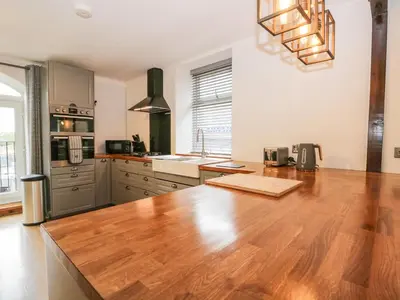 a kitchen with a wooden counter top in a room at Coach House in Carnforth