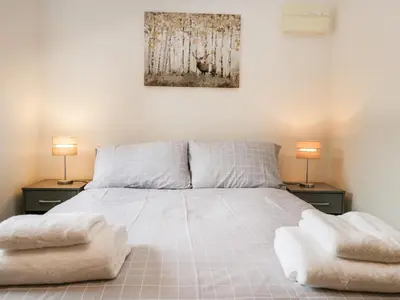 a bedroom with a bed with two lamps on two tables at Coach House in Carnforth