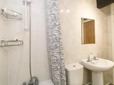 a bathroom with a shower and a sink and a toilet at Coach House in Carnforth
