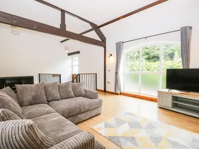 a living room with a couch and a flat screen tv at Coach House in Carnforth