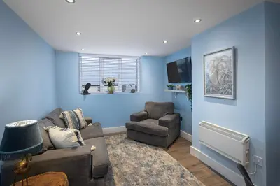 a blue living room with a couch and a chair at Coral Boutique Apartment 3 in Blackpool